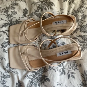 Beige sandaletter med klack - Säljer dessa fina sandaletter från NAKD. Endast provade inomhus. Nypris 549kr. Skickas i originalfärpackning. 