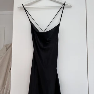 Svart sommar klänning  - Fin svart klänning från H&M i storlek 34. Den är öppen och korsas i ryggen. Säljer då den inte används. 
