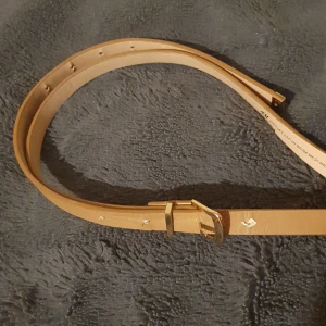 Brunt H&M skärp - Ett gulligt smalt brunt/beigt skärp ifrån H&M, använt någon gång men inte min stil längre