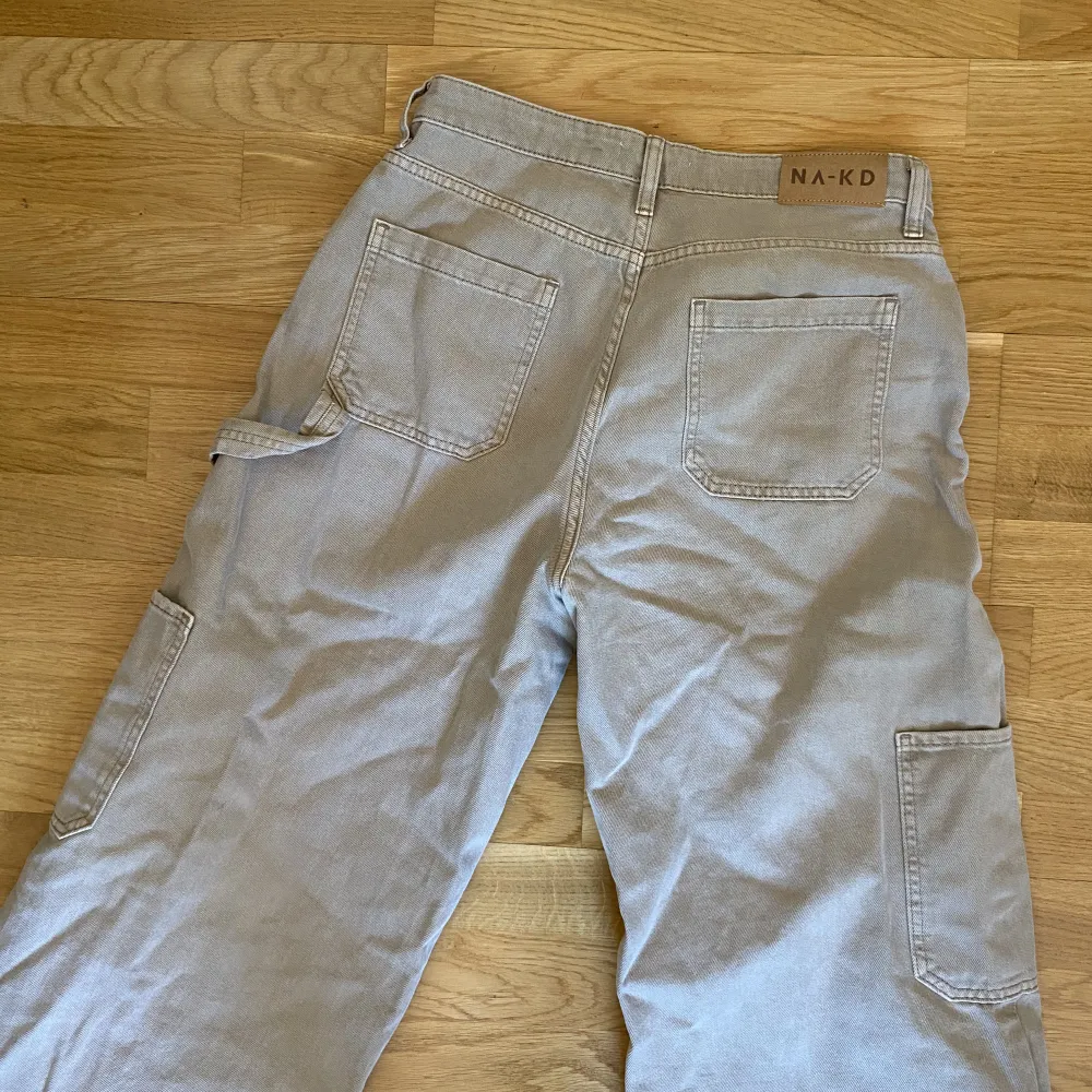 Jeans i cargomodell från NA-KD, långa! Knappt använda, snygg beige färg och high waist. Jeans & Byxor.