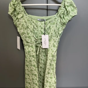 Klänning från MisslissibellXNA-KD - Jag säljer en superfin klänning ifrån misslisibells kollektion med NA-KD. Jag har aldrig använt klänning och lappen sitter kvar. Storleken är i 34 men den går att anpassa i storlek och hur man vill att den ska sitta med hjälp av snören! 