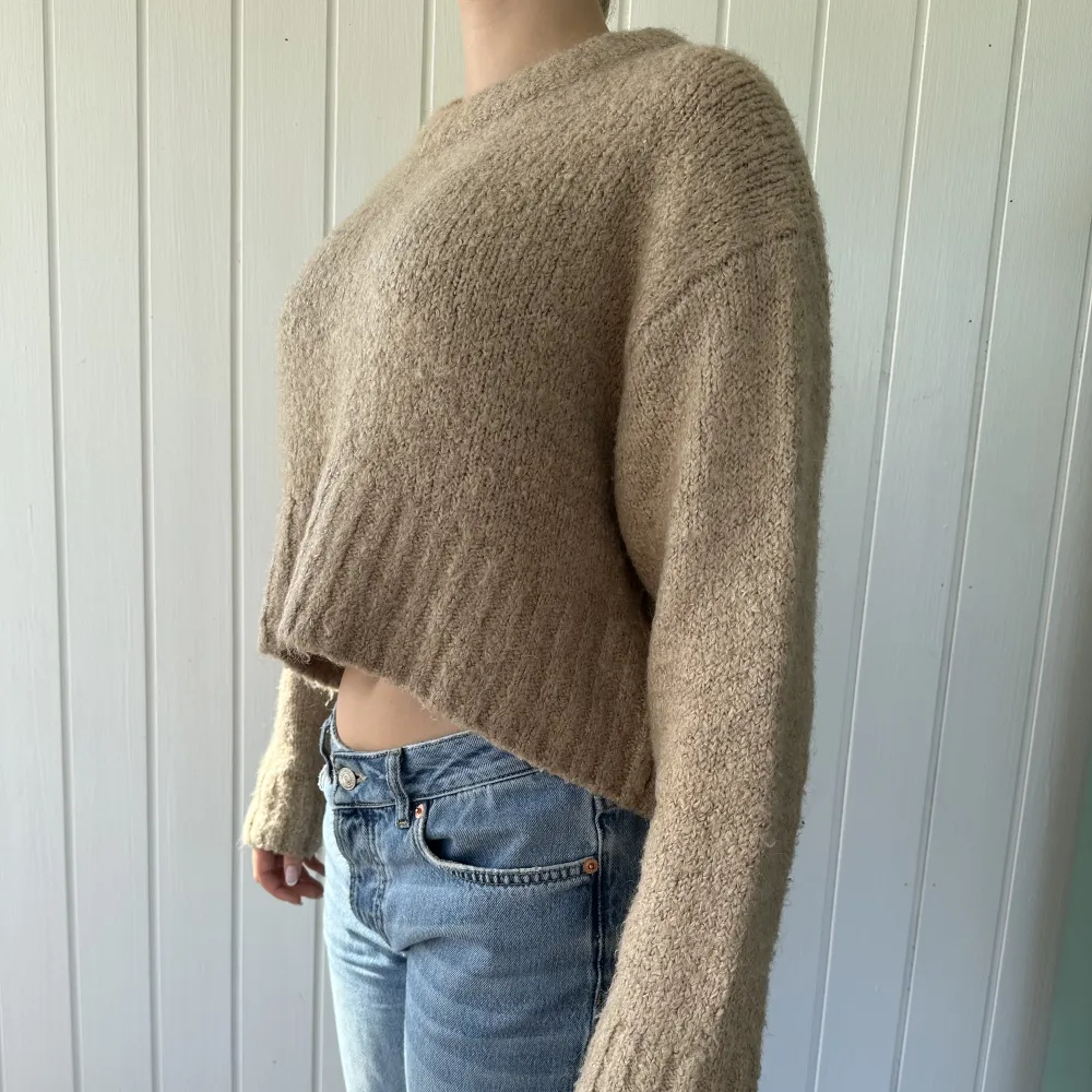 En beige/brun stickad sweater som är lite mot det croppad håller. Supersnygg och enkel att styla. . Stickat.