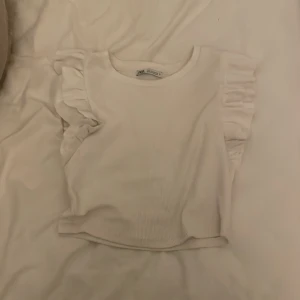 Volang tröja  - En fin vit volang tröja från zara! Den är vit och har stora fina vita volanger på armarna. Köparen står för frakten.
