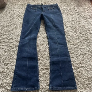 Lågmidjade bootcut jeans - Lågmidjade bootcut jeans i mörkblå färg. Mycket fint skick. Midjemått-76cm, innerbenslängd- 78cm. 