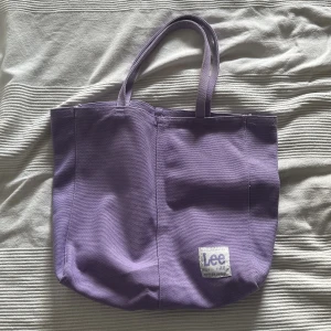 Lila tote bag  - Säljer en fin lila totebag från hm och Lee collaben. Nästan helt oanvänd. Skriv om ni har några frågor och använd gärna köp nu knappen 💕