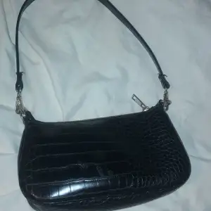 De är en svart hand väska med silver kedjor som är ifrån Gina trickot den e använd 3 gnr och köptes för 200 men säljer för 99