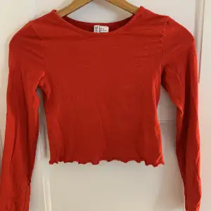 Fin röd långärmade tröja från H&M med detaljer på ärmarna och magen. Storlek xs men passar även en s. Fint skick.
