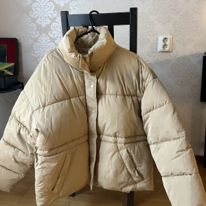 Beige Vinterjacka Puffer - Puffer jacket i Beige Strl 32, men är mer oversized passar mig som vanligt har 36. Använd 1-2 gånger. Säljer då jag har två. 