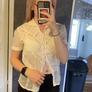 Vit blus - En härlig vit blus med spets i fram och otroligt vackra knappar. ✨ Den är figursydd och kommer från min mormor så jag kan inte säga hur mycket den varit använd. 🫶 Framkommer inte storlek men den passar någon som är S.  Säljer pga att den ej används. 