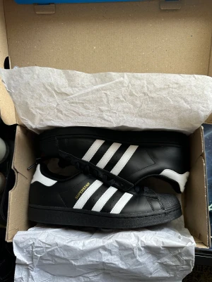 Adidas superstar - Svarta adidas superstar. Använda två gånger. Nyskick. Kvitto finns. Storlek 42,5. Nypris 1300kr.  