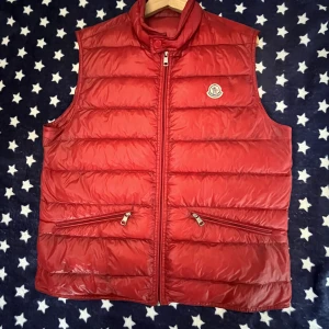 Moncler gui väst - En moncler gui väst. Storlek 4(L). Köpt av amheat. Hör av dig om du har några frågor eller vill ha bild på industri tags. Jag lägger ej ut dom här utan såfall får man fråga om dem eftersom några själ och använder dem för eget bruk. Priset är ganska fast!!