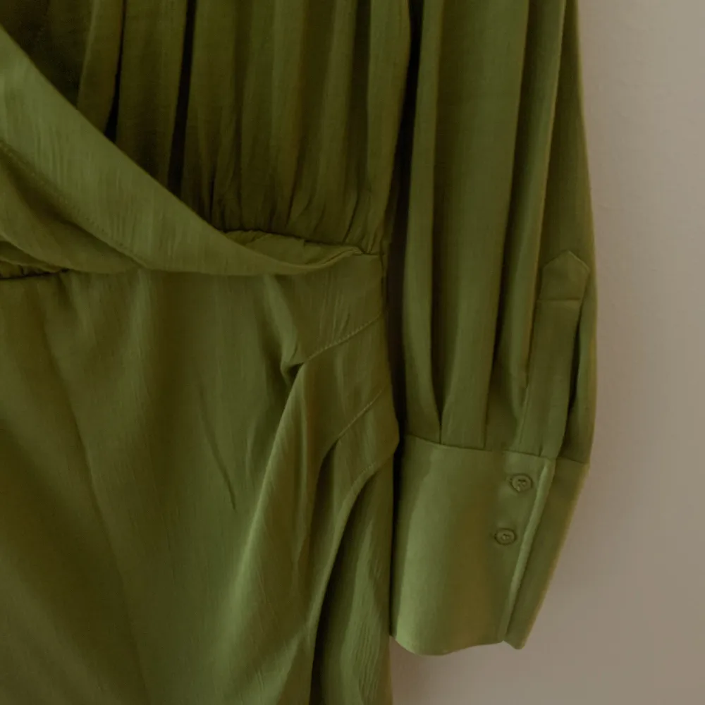 Säljer denna super fina klänningen från H&M som jag köpte för ca 1 år sedan. Aldrig använt den. Jätte fin oliv grön färg!. Klänningar.
