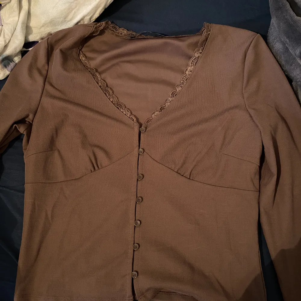 En typ brun lite mörkrosa tröja från bikbok, jätte fin med alla detaljer men för stor för mig, den är i storlek L och skulle inte säga att den passar någon som pendlar mellan S/M utan mer M/L. Toppar.