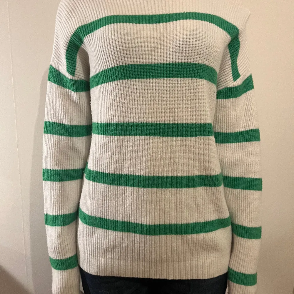 Vit stickad tröja med gröna streck från VILA. Fint skick. Den är lite högre vid nacken än vad det brukar vara. Den är lång i armarna och är lång i själva tröjan också så är perfekt nu till vintern för att hålla sig varm. Skriv för frågor och bilder🫶. Tröjor & Koftor.
