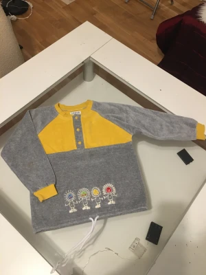 Barn tröja - Barn tröja 100%coton .tjock i material och varm . Tre knappar framme som går att öppna. Och snöre längs ner som man dra åt . Det står nummer 8 .kan tänka i ålder 6-7 år 