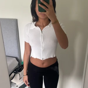 Vit tröja - Vit tröja med dragkedja både upp och ner. Den är stretchig och väldig bekväm, den anpassar sig efter passformen. Nyskick. Aldrig använt.