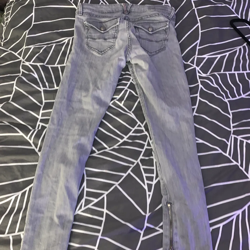 Grå low waist jeans med dragkejda nere (möjlighet till slits) och snöre i sömmen, ger möjlighet till att knyta åt och spänna byxorna bättre. Storlek XS/S(/M). Märket är oklart.. Jeans & Byxor.