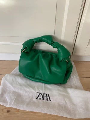 Handväska från Zara - Säljer denna fina gröna handväskan från Zara som endast är använd 1-2 gånger. 21 cm bred!