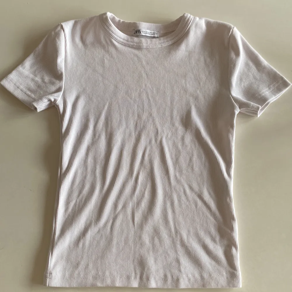 En vit ribbad t shirt från zara i storlek S. Är i väldigt bra skick, bara använd en gång. Säljer pga att den inte kom till användning.. T-shirts.