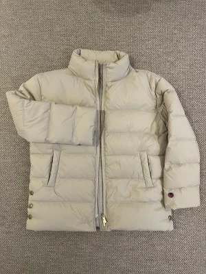 Vinterjacka Busnel Isadora down jacket - Busnel Isadora down jacket, 21024JA, sand, strl. 36, stor i storlek, passar 38 Helt oanvänd! Fin dunjacka med hög krage, dragkedja, två fickor, tre tryckknappar på varje sida.  Nypris 5495-prislapp kvar 4000kr eller bud 