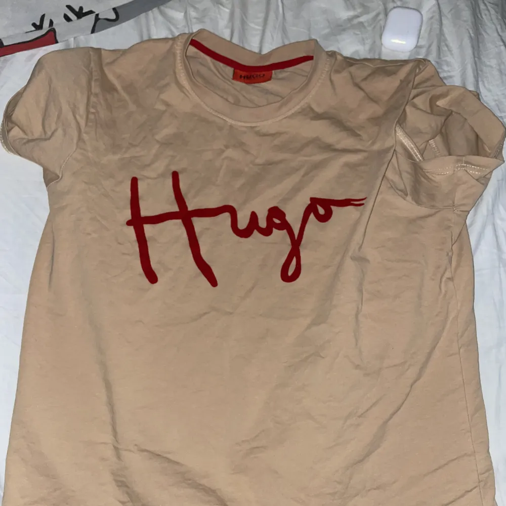 En jättefin beige/brun hugo boss tröja med jätteskönt material (bomull?) som text, vet inte om den är äkta men qr koden tar dig direkt till deras hemsida L passar M!!. T-shirts.