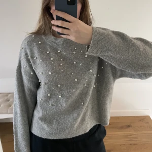 Stickad tröja - Grå stickad tröja från HM med pärlor och stenar. Säljer pga att jag inte använder så mycket men i fint skick! Är storlek M men skulle säga att den känns mer som L😁