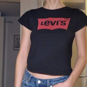 Levi's T-shirt. Något croppad (slutar precis vid naveln). Litet hål starx under armhålan, bör vara lätt att laga.