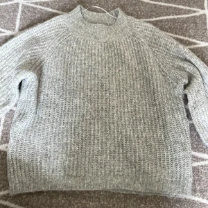 Stickad tröja med turtleneck - En jättefin stickad tröja med en kort turtleneck som är i bra skick och använd fåtal gånger.
