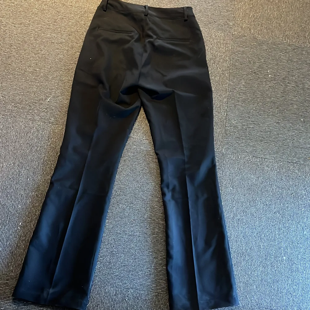 Svarta utsvängda kostymbyxor ifrån bikbok.ny Skick men endast använd 2 gånger.. Jeans & Byxor.