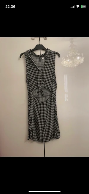 Klänning - Fin klänning med ett hål vid mage, den har knappar och man kan även knyta den. Lite missfärgad men det syns knappt, se bild 3