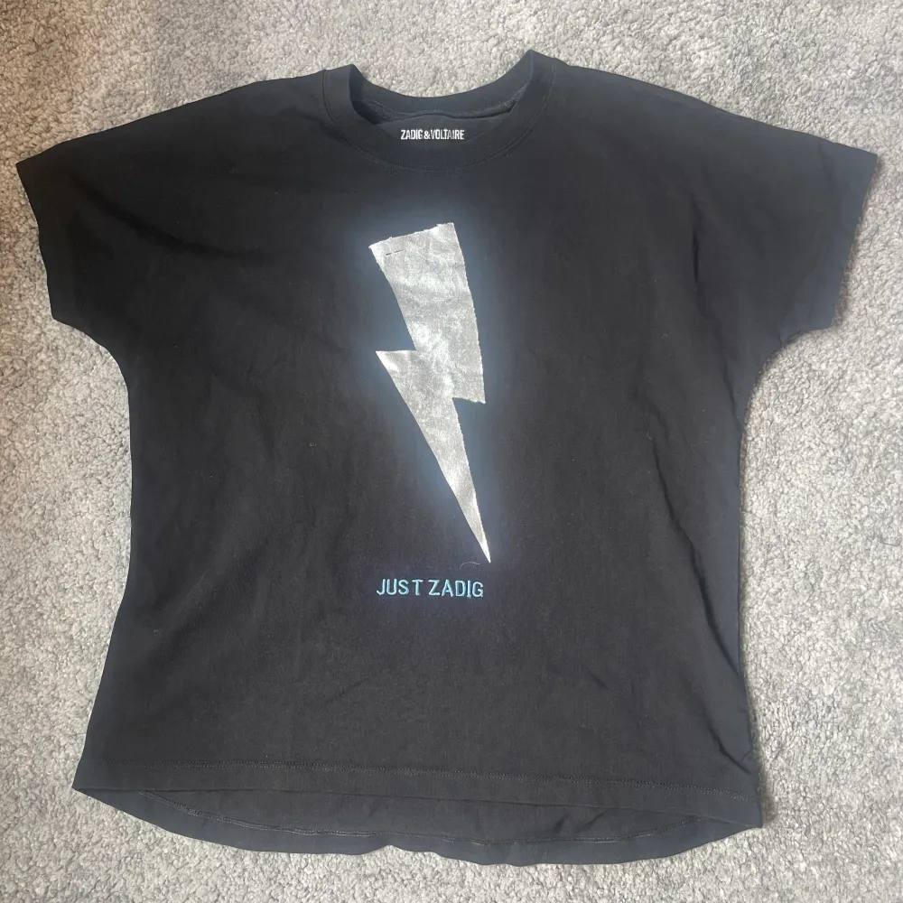 Säljer denna jättefina t-shirten från zadig! 💖 Använd men i fint skick men trycket har flagnat lite (kontakta för mer bilder på det). 🙌🏻 står att den är i strl 14/S men passar mig som har XXS-S i tröjor. 💞 säljs då den inte kommer till användning. nypris ca. 400kr. Frakt tillkommer, kontakta mig vid frågor mm. 🥰. T-paidat.