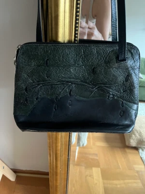 Skinnväska  - Skinnväska köpt vintage. Aldrig använd av mig och den är i fint skick. Finns fack inuti väska. Och att långt axelband. 17 höjd & 27 bred ish