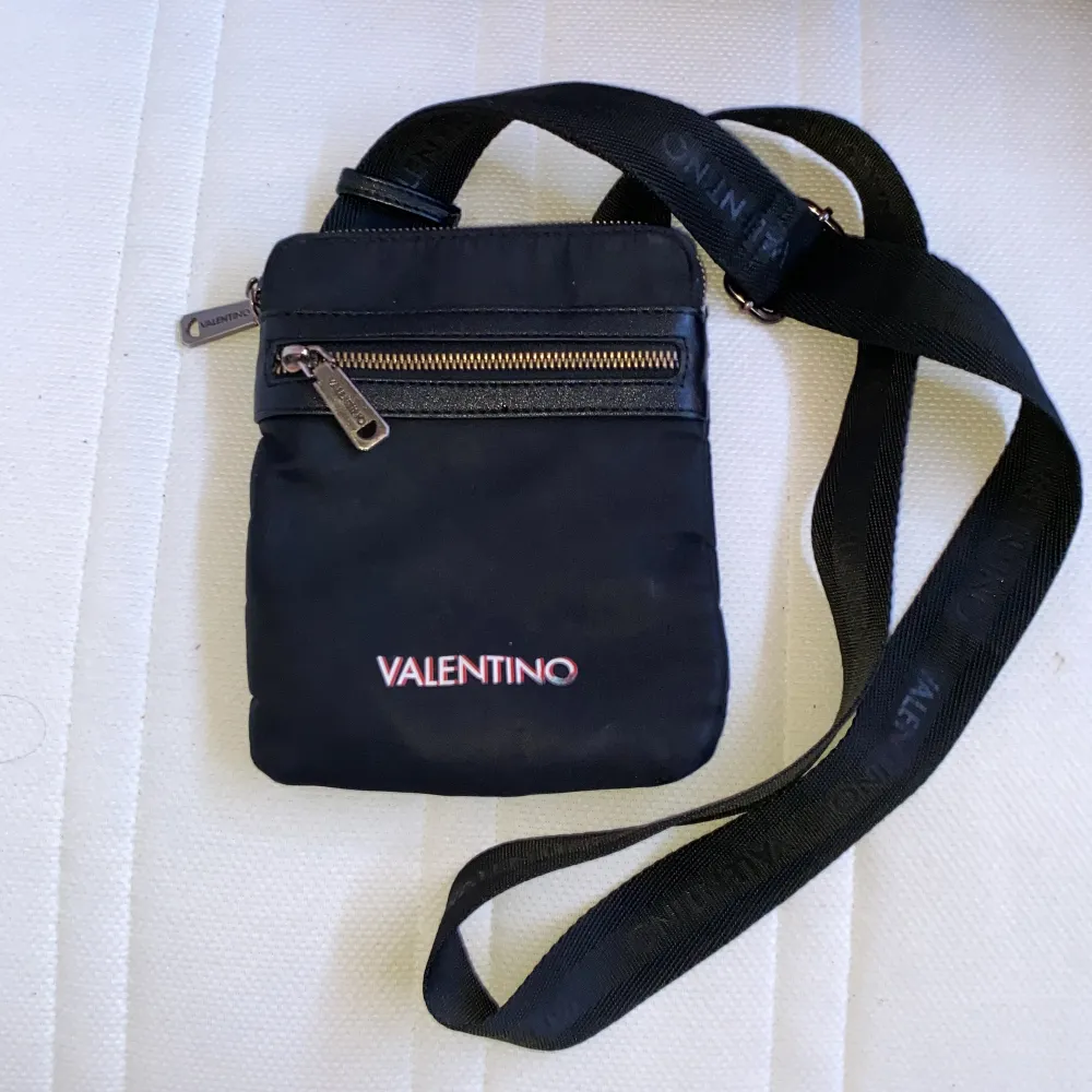 En smal valentino axelväska köptes från Valentin original hemsida för 1 och ett halv år sen. Men är fortfarande i bra skick o inget fel med den. . Väskor.
