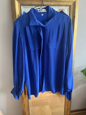 En blå skjorta köpt vintage men aldrig använd av mig och den är i jättegott skick. 