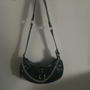 svart väska  - väska från new yorker köpt för 100kr tror jag. Använd inte köp nu🩷 man kan nog ”klippa” av kedjan om man vill