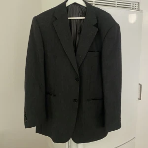 Grå ullkavaj - Mörkgrå oversize kavaj i ull, därav varm och kan användas som jacka. Väldigt snygg, köpt secondhand.