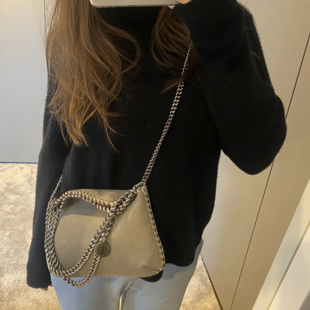 En sååå fin Stella McCartney Väska i grå färg med silver kedjor. Köptes helt ny på Miinto 2021💕 Bredd: 28 cm och höjd: 21 cm Den är i super bra skick🩷 (Nypris 6000kr - säkert lite mer nu)❄️. Väskor.