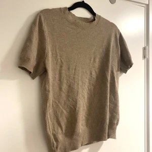 Stickad T-shirt  - Säljer denna beiga, stickade T-shirten🫶🏼 den är helt ny och oanvänd!! Står ej storlek men skulle säga S