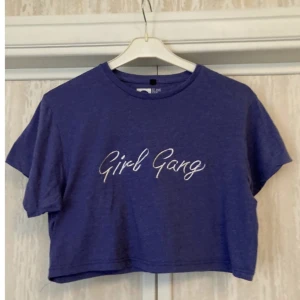 Lila t-shirt magtröja girl gang 90-tal - Lila magkort tröja 90-tals stil Girl Gang. I superbra skick! Mått:  49 cm armhåla-armhåla.  37 cm längd. Finns att hämtas upp i Stockholm! Titta gärna in mina andra annosner och hör av dig om du har någon fundering!
