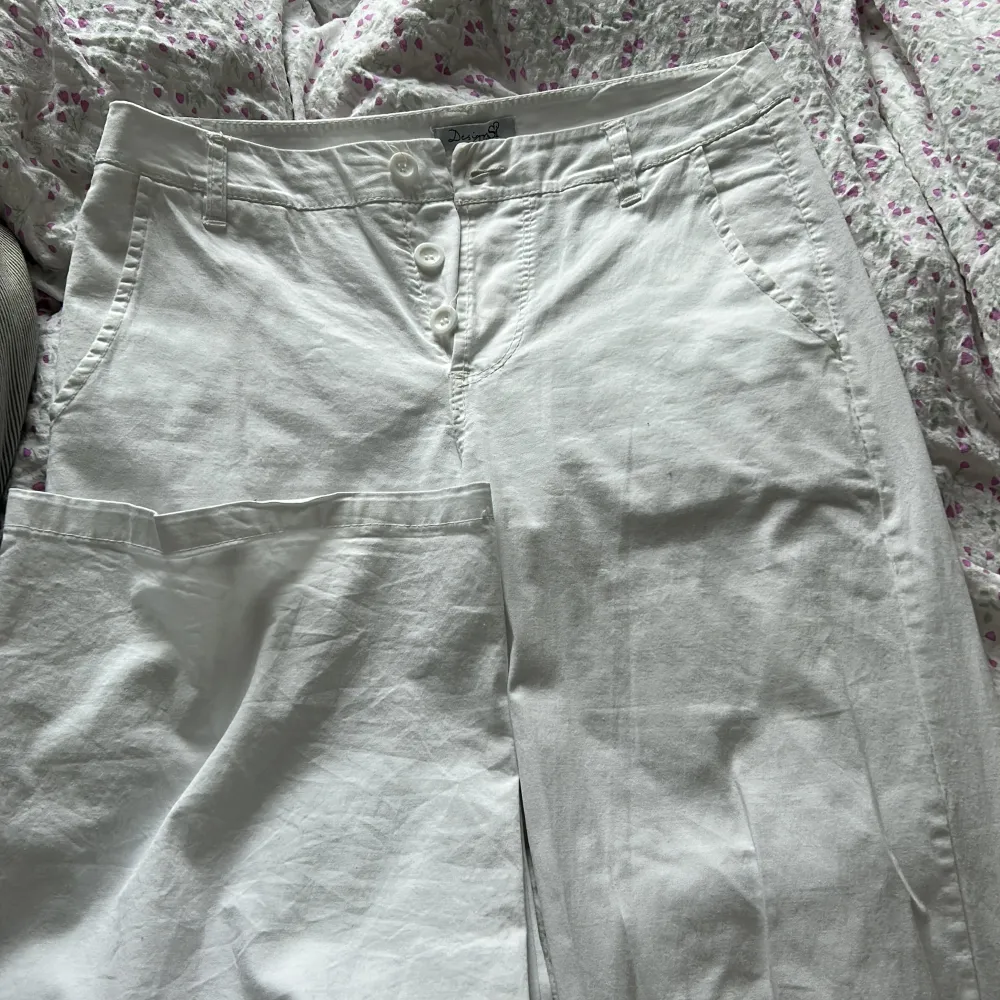Ett par vita lågmidjade chinos/linnebyxor från DesignBySI. Sitter sjukt fint på och har utsvängda ben . Jeans & Byxor.