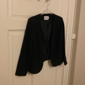 Öppen kavaj från Size & Needle  - Säljer denna snygga kavajen från Size & Needle. Storlek L, passar som S/M. I fint skick. Ej knäppning. Öppen kavaj. Fickor framtill. 