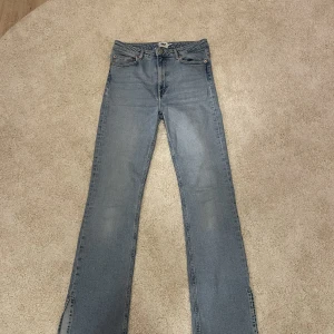 Blå jeans med slits!  - Dom är höga i midjan och har en slits i slutet på byxan. Dom är inte i ny skick och tvättade några gånger men har inga hål. (Porto tillkommer) 