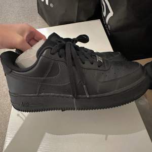 Hej! I och med rensning hemma säljer jag dessa svarta Nike Air Force 1. Storlek 39 Dam. Använda ett fåtal gånger annars stått i garderoben med papper i för hålla formen. 