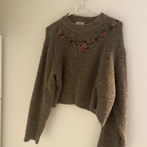 Brun tröja med blomdetaljer - Brun stickad tröja med unika detaljer längs bröstet. Fråga för fler bilder:)