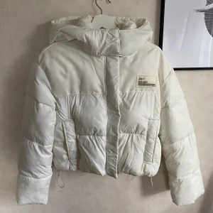 Bershka Puffer Jacket - Off-white vinterjacka från Bershka i croppad modell! 
