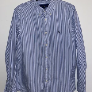 Ralph lauren skjorta - Blåvit randig Ralph lauren skjorta i storlek 18. Använd några gånger men är fortfarande i bra skick, säljer den pga att den blivit för liten. Köparen står för frakten.