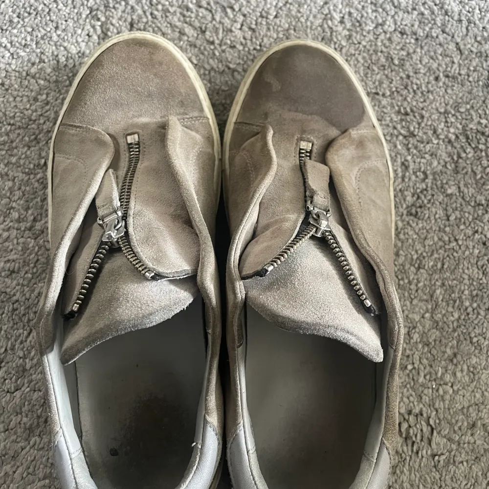 Snygga grå arigato skor med zip, storlek 42, tillkommer box och sko påse. Dom är i bra skick förutom lite fläckar på olika ställen. Hör av er vid frågor eller funderingar 😊. Skor.