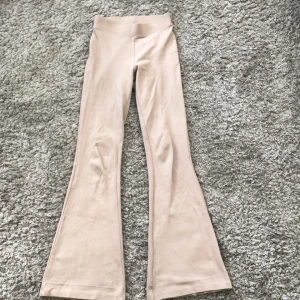 uUtsvängda byxor  - Ett par jätte snygga beiga utsvängda byxor från Gina Tricot i storlek xxs. Säljer för att jag har växt ur dem. De är i ganska bra skick men de har en liten slitning, se på tredje bilden. 10 kr + frakt.