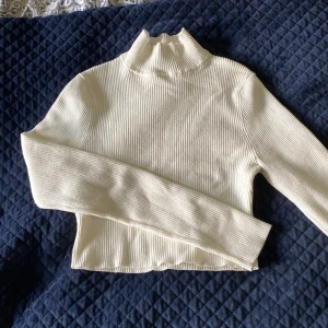 Kort polotröja  - Ribbstickad polotröja från hm strl S. Använd och har en liten fläck vid halsringen (bild 3) som knappt syns men borde inte vara något problem att få bort. Lite nopprig på magen.