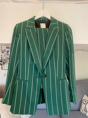 Grönt kostymsett - Randigt kostymsett från HM med matchande kavaj och byxor. Kavaj storlek 36 och byxor i storlek 38.